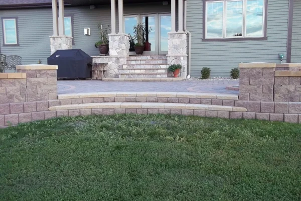 A well-constructed stone patio with a matching stone wall and steps, creating an inviting outdoor space.