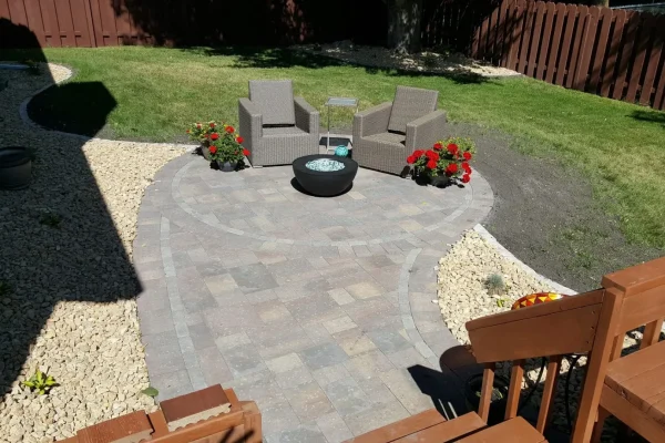A cozy backyard patio featuring a fire pit surrounded by comfortable chairs for relaxation and social gatherings.