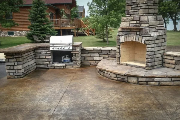 A stone patio featuring a grill and a cozy fire pit, ideal for outdoor gatherings and relaxation.