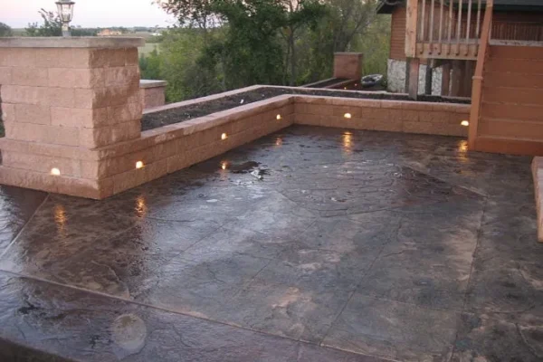 A concrete patio illuminated by decorative lights, creating a warm and inviting outdoor atmosphere.
