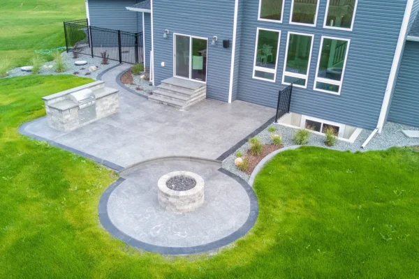 A backyard featuring a cozy fire pit surrounded by a patio area, ideal for outdoor gatherings and relaxation.