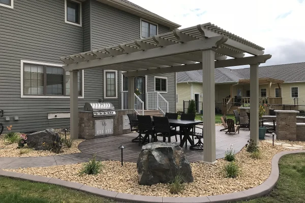 A backyard featuring a pergola and grill, creating an inviting outdoor space for relaxation and dining. | Landscaping and Outdoor Living Services