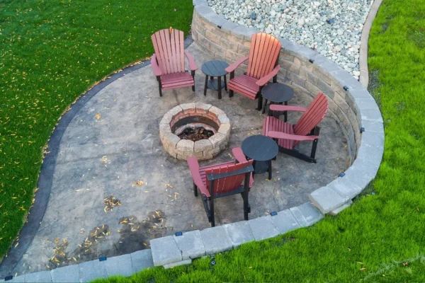 Aerial view of a patio featuring a central fire pit surrounded by seating and greenery.
